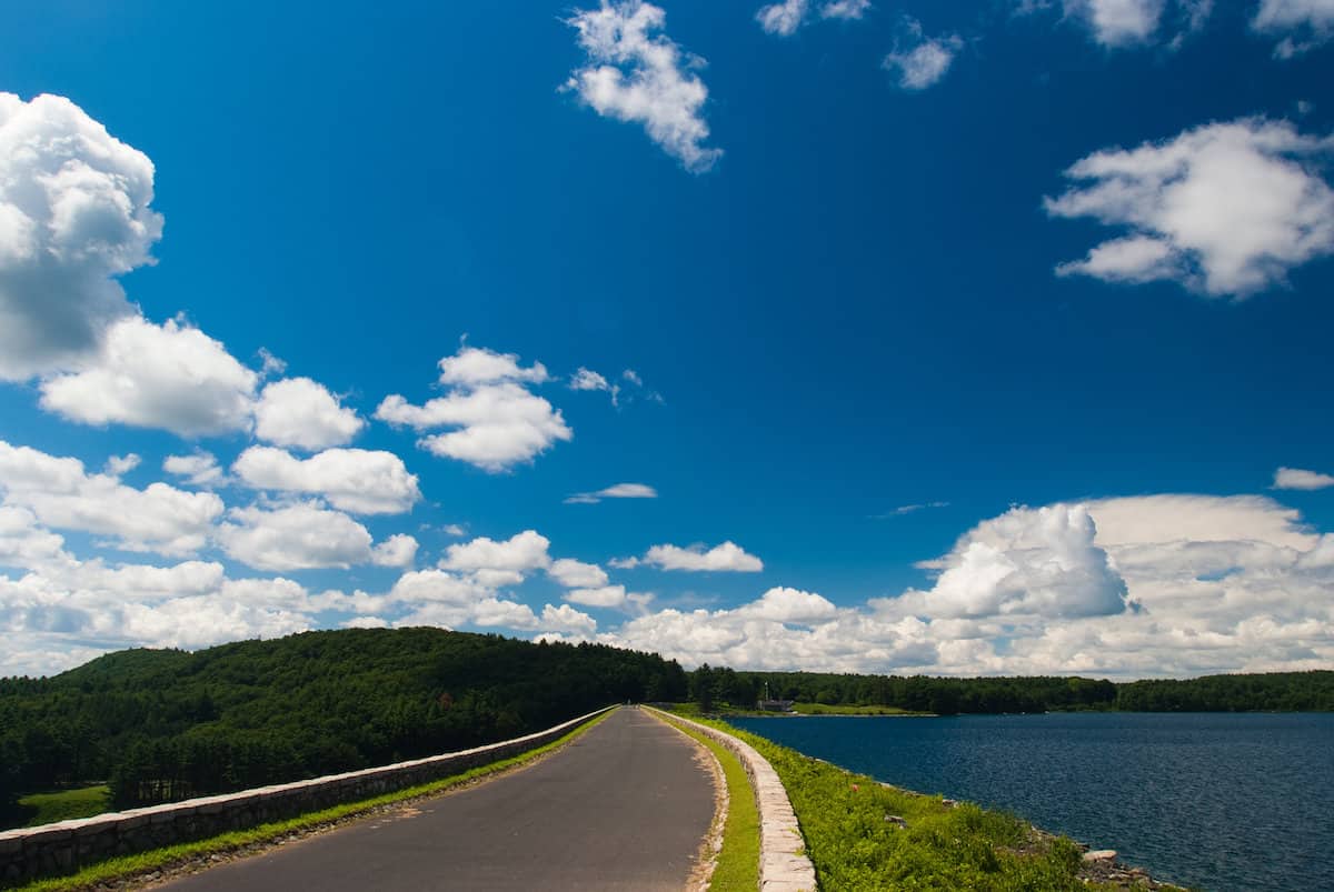 Scenic photo of a roadway along the edge of Quabbin Reservoir, a top fishing spot in Massachusetts.